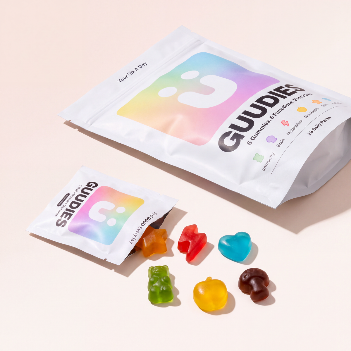 GUUDIES daily gummy pouches with the six shaped gummies spilled out beside them